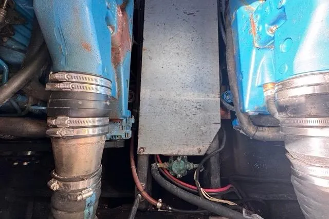 Slide: The Image of Engine components of a 1987 Carver 32 Aft Cabin Motor Yacht, featuring blue machinery and hoses. - 72