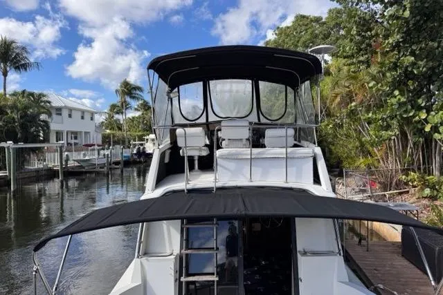 Slide: The Image of 1987 Carver 32 Aft Cabin Motor Yacht docked by tropical waterfront homes. - 12
