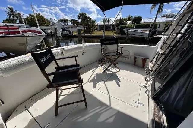 Slide: The Image of 1987 Carver 32 Aft Cabin Motor Yacht deck with chairs, docked by waterfront. - 17