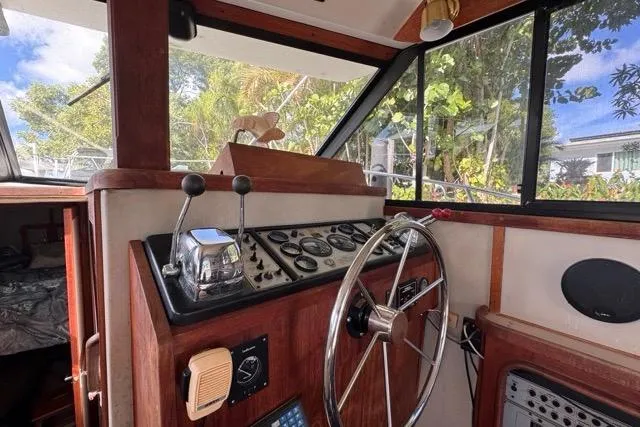 Slide: The Image of 1987 Carver 32 Aft Cabin Motor Yacht helm with classic controls and wooden accents. - 34