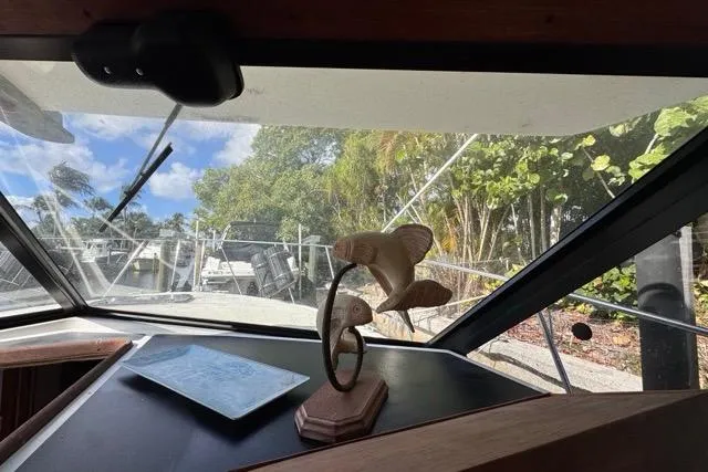 Slide: The Image of 1987 Carver 32 Aft Cabin Motor Yacht interior with decorative fish sculpture and marina view. - 35