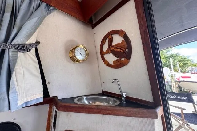 Slide: The Image of 1987 Carver 32 Aft Cabin Motor Yacht interior with sink, clock, and decorative wall art. - 38