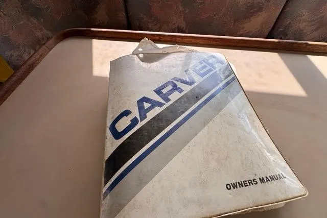 Slide: The Image of 1987 Carver 32 Aft Cabin Motor Yacht owner's manual on a table. - 39