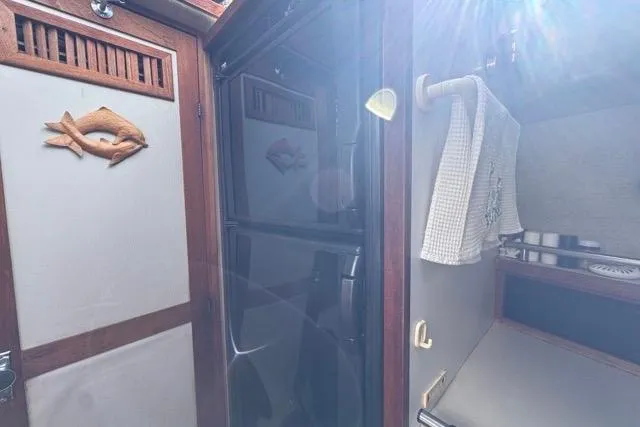 Slide: The Image of 1987 Carver 32 Aft Cabin Motor Yacht interior with wooden accents and kitchen area. - 43