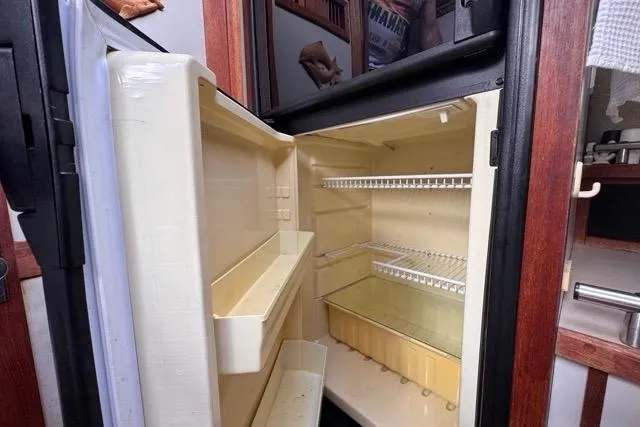 Slide: The Image of 1987 Carver 32 Aft Cabin Motor Yacht interior fridge, open and empty. - 46