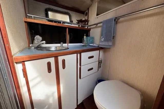 Slide: The Image of 1987 Carver 32 Aft Cabin Motor Yacht bathroom with sink, storage, and toilet. - 50
