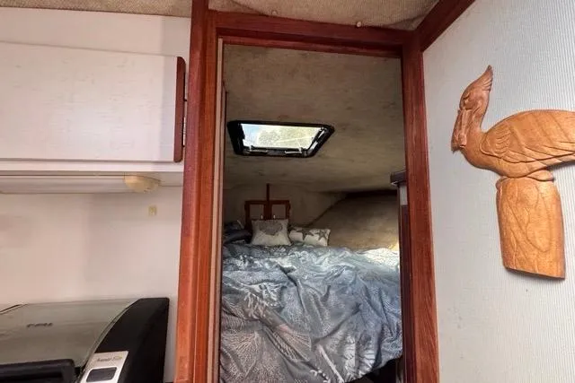 Slide: The Image of 1987 Carver 32 Aft Cabin Motor Yacht interior with cozy bed and decorative wall art. - 53