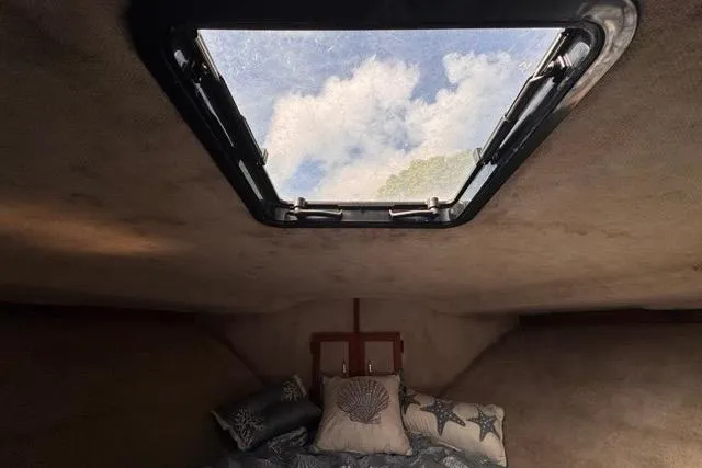 Slide: The Image of Interior view of 1987 Carver 32 Aft Cabin Motor Yacht with skylight and cozy bedding. - 56