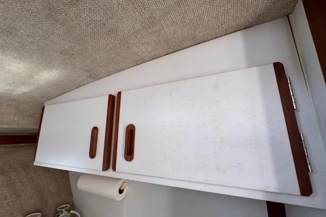 Slide: The Image of 1987 Carver 32 Aft Cabin Motor Yacht interior with white cabinets and wooden handles. - 57