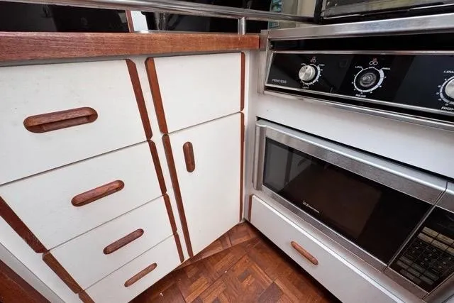 Slide: The Image of 1987 Carver 32 Aft Cabin Motor Yacht kitchen with wood cabinets and built-in oven. - 58