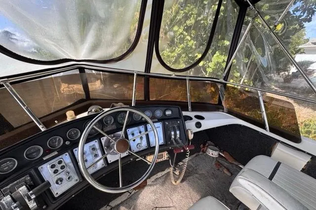 Slide: The Image of 1987 Carver 32 Aft Cabin Motor Yacht helm with vintage controls and steering wheel. - 60
