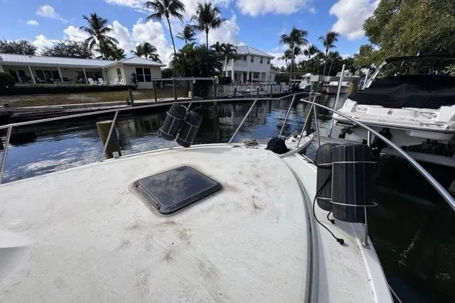 Slide: The Image of 1987 Carver 32 Aft Cabin Motor Yacht docked near waterfront homes and palm trees. - 66