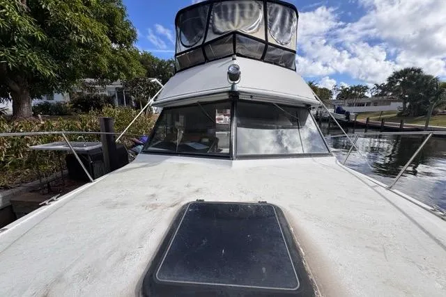 Slide: The Image of 1987 Carver 32 Aft Cabin Motor Yacht docked by lush greenery and calm waters. - 68