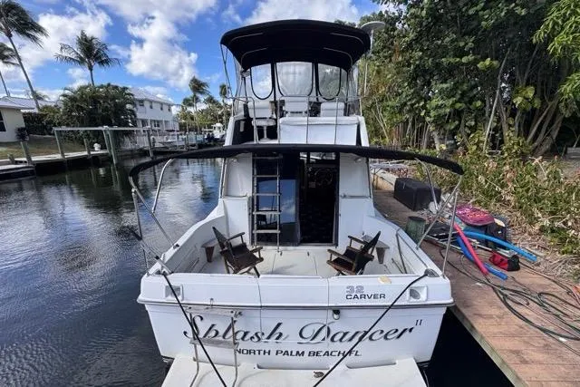 Slide: The Image of 1987 Carver 32 Aft Cabin Motor Yacht docked, named "Splash Dancer," in a scenic canal setting. - 9