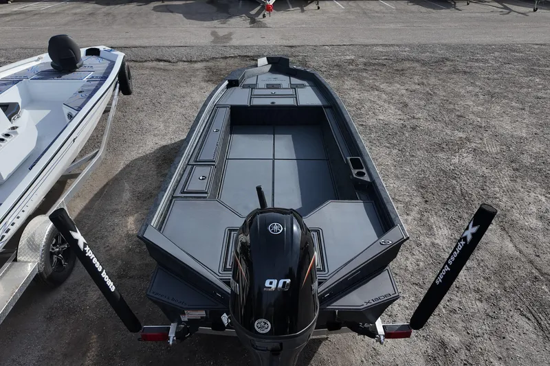Slide: The Image of 2026 Xpress X18DB boat with Yamaha motor, parked on gravel. - 7
