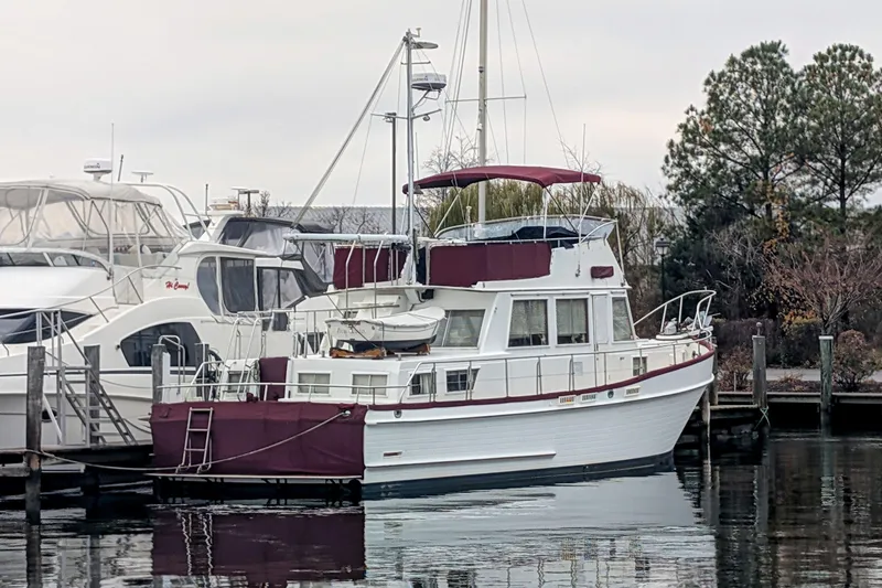 Slide: The Image of 1988 Grand Banks 46 Classic yacht docked at marina with maroon canopy. - 1
