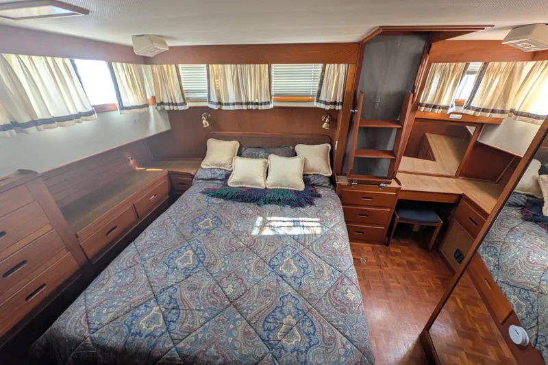 Slide: The Image of Cozy bedroom in 1988 Grand Banks 46 Classic yacht with wood furnishings and patterned bedding. - 13