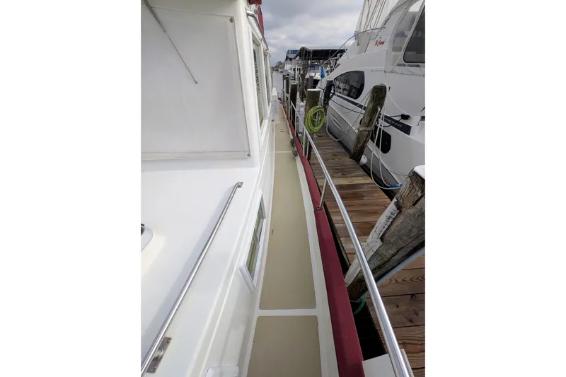 Slide: The Image of 1988 Grand Banks 46 Classic yacht docked, showcasing side deck and railing. - 3