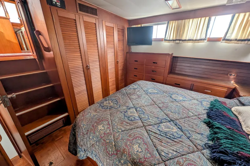 Slide: The Image of Cozy bedroom in 1988 Grand Banks 46 Classic yacht with wood paneling and patterned bedding. - 31