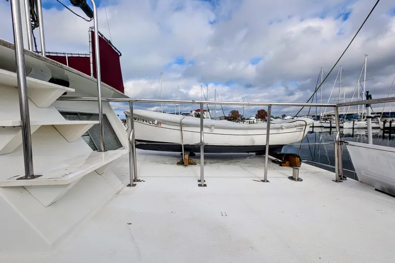 Slide: The Image of 1988 Grand Banks 46 Classic yacht deck with dinghy, docked at marina under cloudy sky. - 4