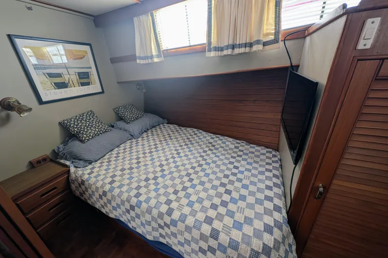 Slide: The Image of Cozy bedroom in 1988 Grand Banks 46 Classic yacht with nautical decor and wood paneling. - 42