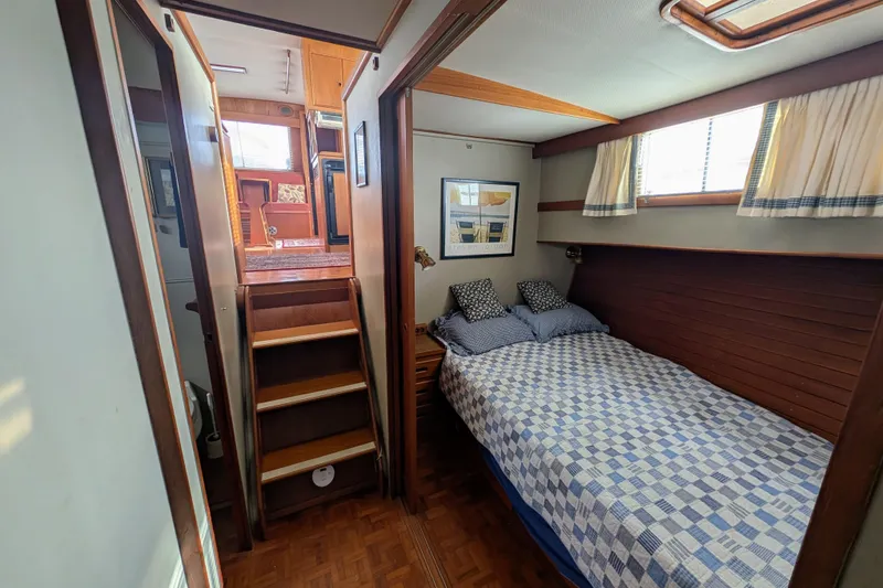 Slide: The Image of Cozy bedroom in 1988 Grand Banks 46 Classic yacht with wooden interior and quilted bedspread. - 48