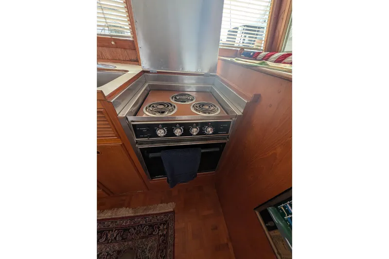 Slide: The Image of 1988 Grand Banks 46 Classic yacht kitchen with stove and wooden cabinetry. - 50