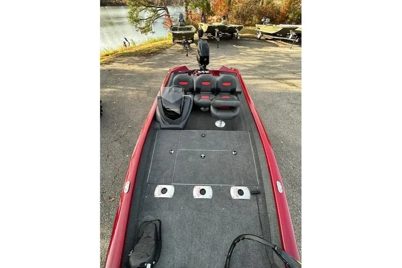 Slide: The Image of 2026 Tracker Pro Team 175 Crappie Edition boat, red exterior, spacious deck, parked near a lake. - 59
