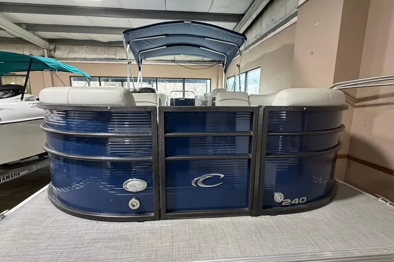 Slide: The Image of 2021 Crest Classic Platinum 240 SLC pontoon boat in showroom, blue exterior, gray seating. - 2