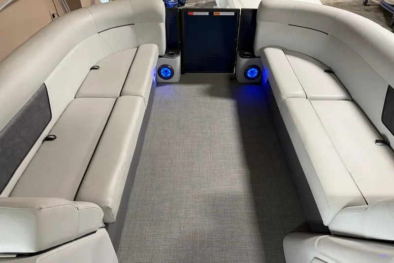 Slide: The Image of Interior of 2021 Crest Classic Platinum 240 SLC pontoon boat with plush seating and blue LED lights. - 7
