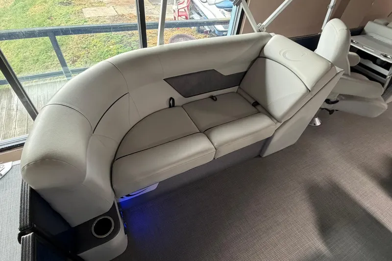 Slide: The Image of 2021 Crest Classic Platinum 240 SLC boat interior with plush seating and cup holder. - 8