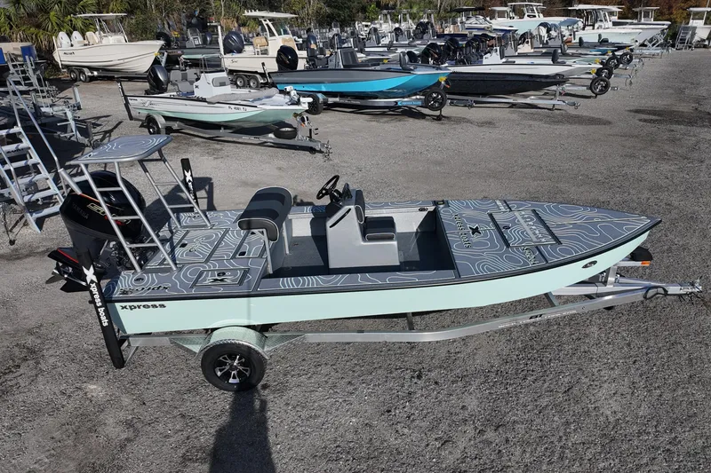 Slide: The Image of 2026 Xpress Skiff 185 boat on trailer in outdoor setting. - 2