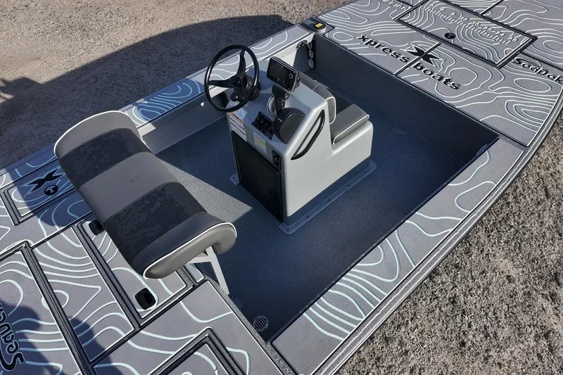 Slide: The Image of 2026 Xpress Skiff 185 boat on trailer in a marina setting. - 8