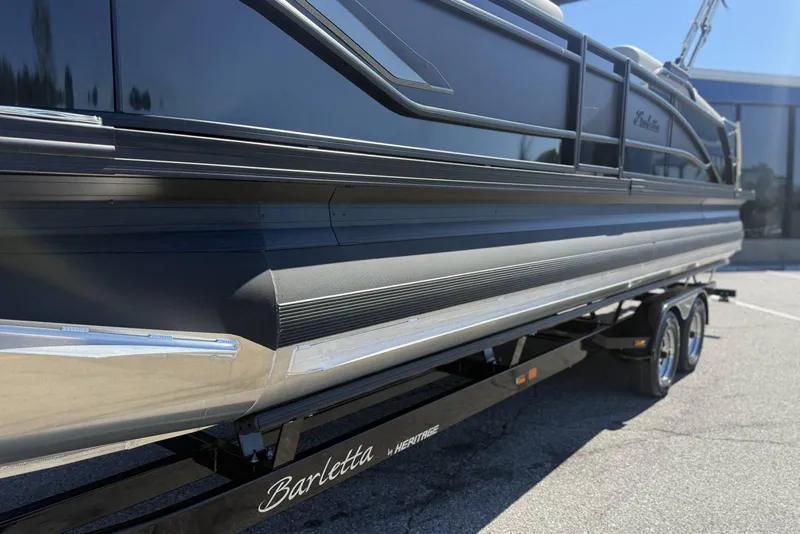 Slide: The Image of 2025 Barletta CORSA 25M pontoon boat on a trailer, side view. - 2