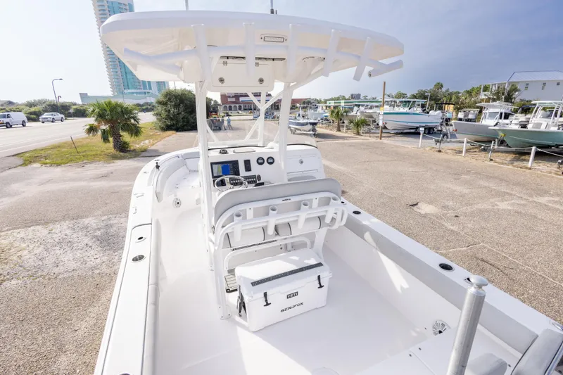 Slide: The Image of 2020 Sea Fox 249 Avenger boat with console and seating, parked near marina. - 19