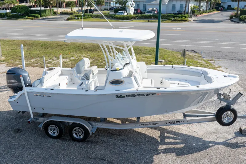 Slide: The Image of 2020 Sea Fox 249 Avenger boat on trailer, parked near a road. - 2