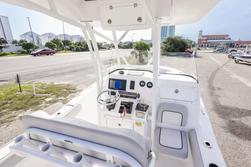 Slide: The Image of 2020 Sea Fox 249 Avenger boat interior with steering console and seating, parked near a road. - 20