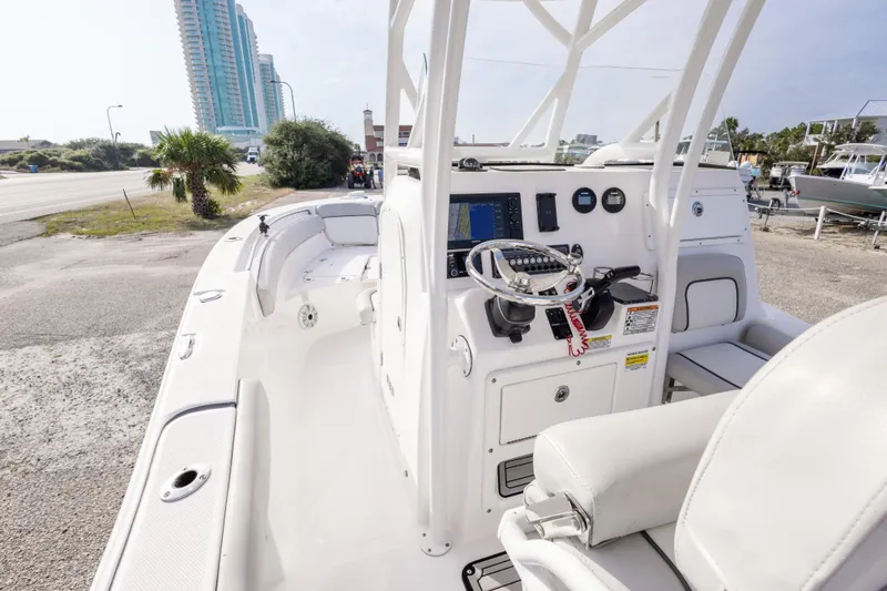 Slide: The Image of 2020 Sea Fox 249 Avenger boat interior with steering console and seating, near coastal area. - 22