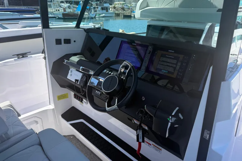 Slide: The Image of 2026 Axopar 29 XC Cross Cabin helm with modern navigation displays and controls. - 21