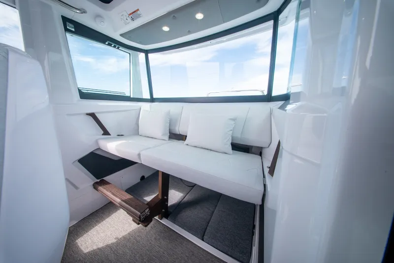Slide: The Image of Interior of 2026 Axopar 29 XC Cross Cabin with white seating and panoramic windows. - 17
