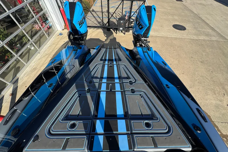 Slide: The Image of 2025 MTI 440X boat with sleek blue and black design, docked outdoors. - 12