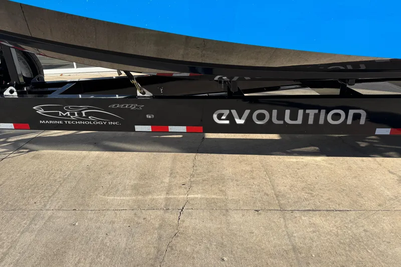 Slide: The Image of Trailer of 2025 MTI 440X boat with "Evolution" branding on pavement. - 19