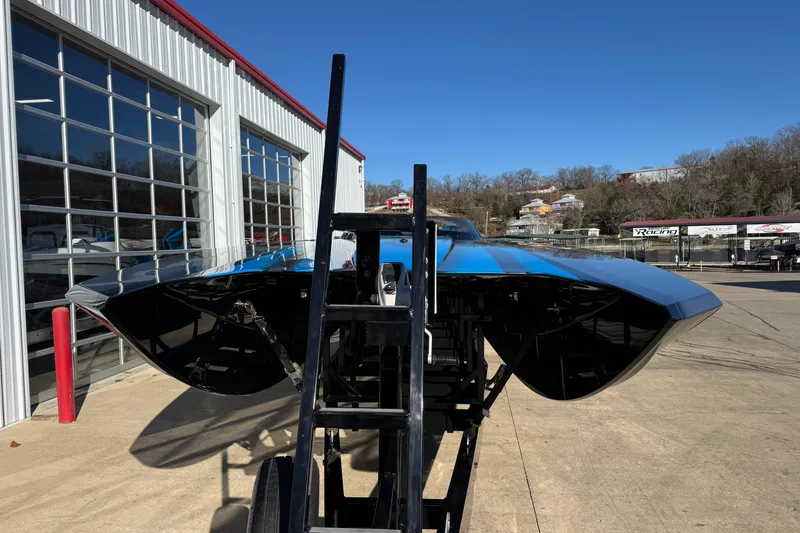 Slide: The Image of 2025 MTI 440X powerboat on trailer outside a garage, under clear blue sky. - 2