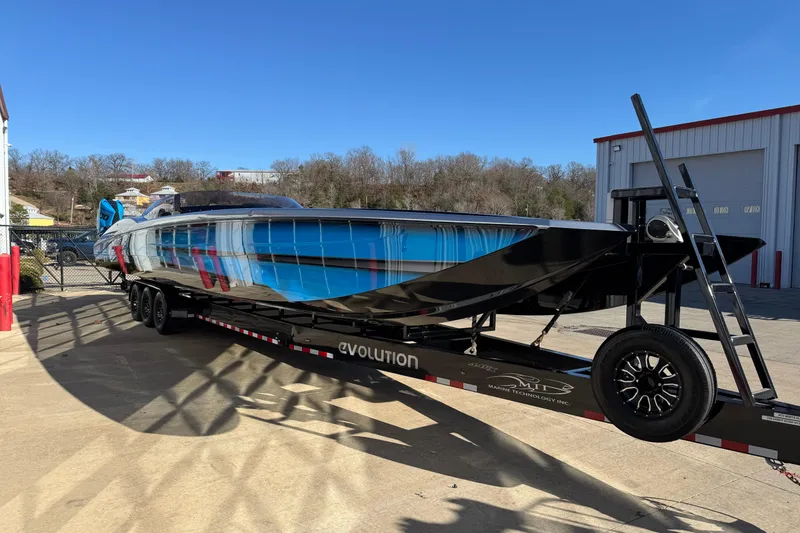 Slide: The Image of 2025 MTI 440X powerboat on trailer, vibrant blue and black design, parked outdoors. - 3