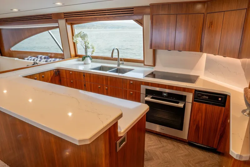 Slide: The Image of Luxurious kitchen interior of 2018 Viking 80 Enclosed Bridge yacht with wood cabinetry. - 15