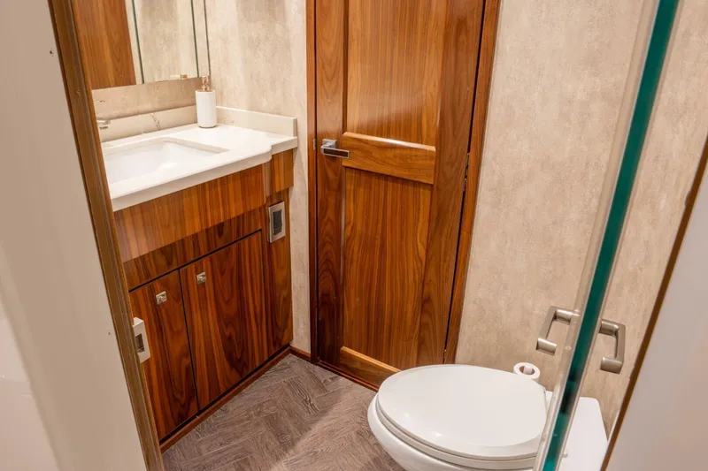 Slide: The Image of Luxurious bathroom in 2018 Viking 80 Enclosed Bridge yacht with wood accents and modern fixtures. - 20