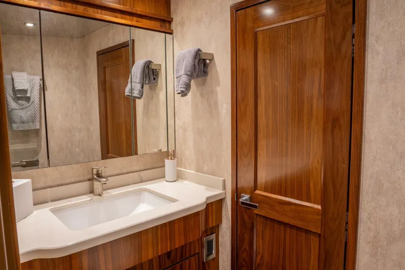 Slide: The Image of Luxurious bathroom in 2018 Viking 80 Enclosed Bridge yacht with wooden accents. - 21