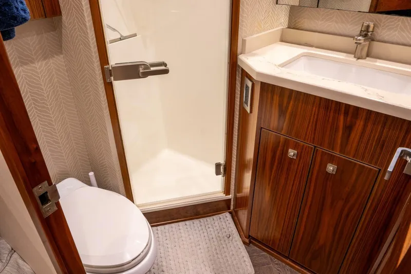 Slide: The Image of Luxurious bathroom in 2018 Viking 80 Enclosed Bridge yacht with wood cabinetry and modern fixtures. - 27