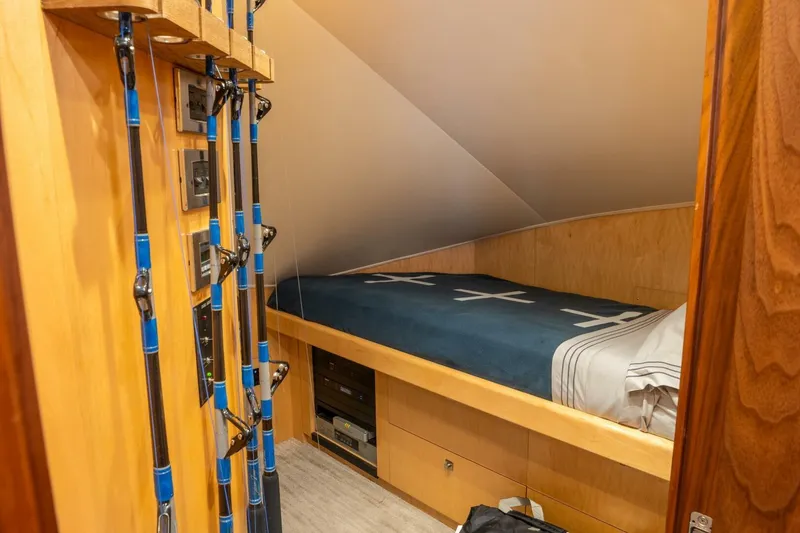Slide: The Image of 2018 Viking 80 Enclosed Bridge cabin with fishing rods and cozy bed. - 39