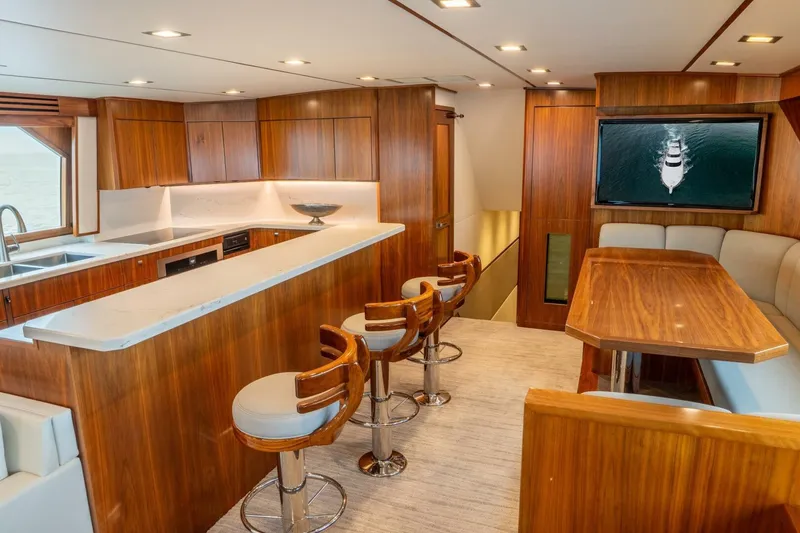 Slide: The Image of Luxurious interior of 2018 Viking 80 Enclosed Bridge yacht with modern kitchen and seating area. - 5